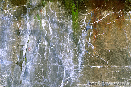 Abstract photograph showing graffiti and patterned cracks in concrete wall