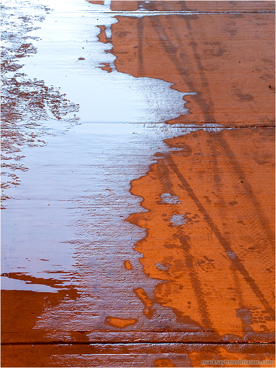 Meltwater, Concrete: Calgary, AB, Canada (2010-02-28) - Abstract photo of a red concrete walkway covered in ice, water and tire tracks
