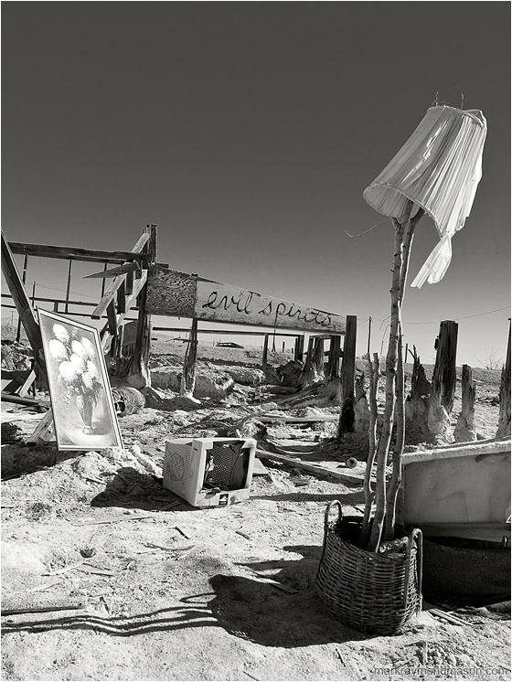 Evil Spirits (B&W): Salton Sea, CA, USA (2012-01-01) - Fine art B&W photograph showing the remains of a structure and scattered objects on a salt flat