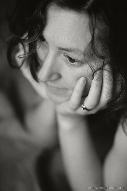 Terri, Daydreaming (B&W): Calgary, AB, Canada (2008-00-00) - Fine art black and white photograph of a beautiful woman with her head in her hands and curled hair on her face