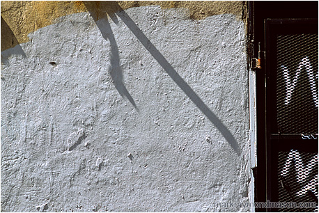 Abstract photograph showing graffiti and light patterns on a painted concrete wall