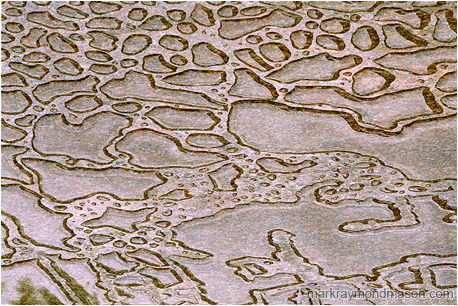 Abstract photograph of beaded water on the surface of a red marble slab