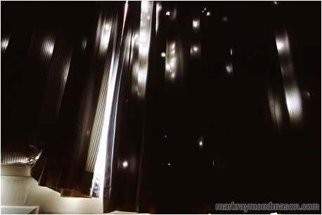 Abstract photograph of light streaming through holes in hotel curtains