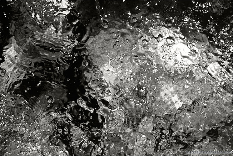 Colourful Sparkling Water (B&W): Kananaskis, AB, Canada (2007-00-00) - Abstract black and white photograph of the bubbling surface of a mountain creek, rendered in contrasted shades of grey
