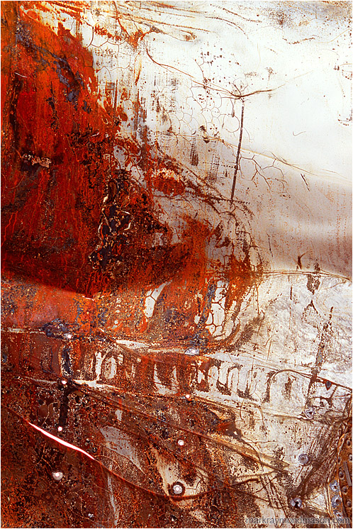 Folded Sheet Metal: Near Baker, CA, USA (2008-00-00) - Fine art photograph of white paint and red rust on the surface of a folded, puntured piece of sheet metal