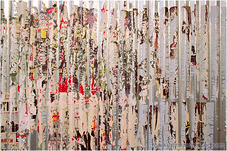 Fine art photograph of scraps of paper and glue clinging to a corrugated metal signboard