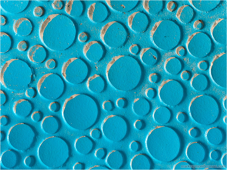 Plastic Circles, Sand: Calgary, AB, Canada (2010-03-27) - Abstract photograph showing an array of blue plastic circles, some partly filled with drifting sand