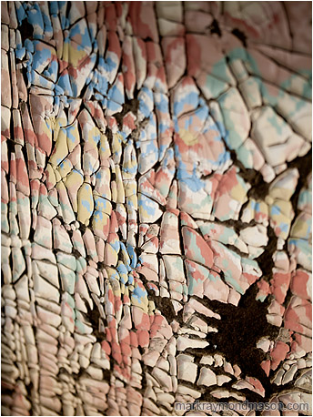 Abstract macro photograph showing crumbled paint and shadows on the side of an old woodshed
