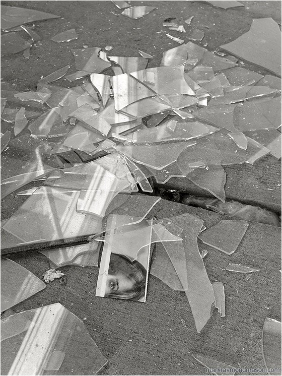 Eyes, Shattered Glass (B&W): Bombay Beach, CA, USA (2011-12-29) - Fine art B&W photo showing a magazine clipping in a pile of shattered window glass