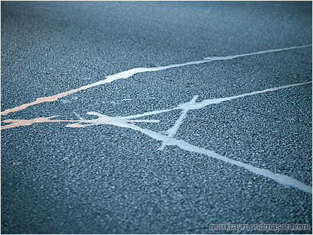 Abstract photograph showing lines of tar intersecting on the surface of an asphalt road