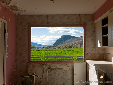 Fine art photograph of a window in a derelict house with missing glass but a beautiful pastoral and mountain view
