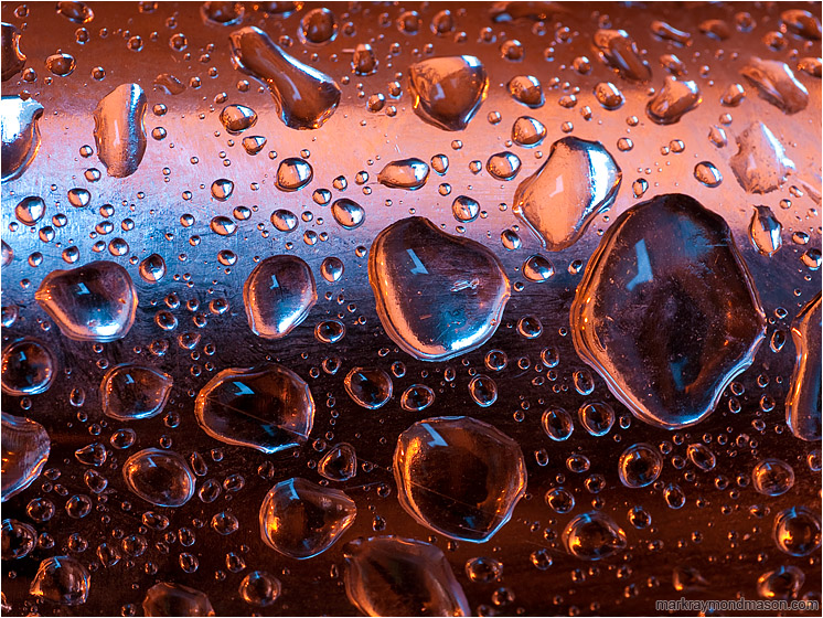 Steel, Clinging Water: Vancouver, BC, Canada (2012-11-11) - Fine art macro photo showing colourful reflected gradients and interlocking water drops on a curved piece of scrap steel