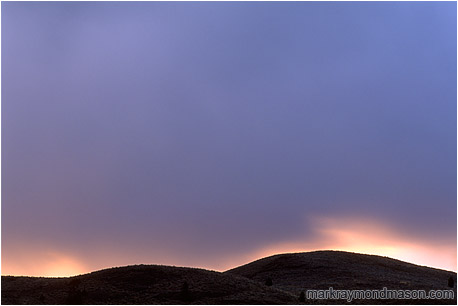 Fine art photograph of storm clouds over the hills at sunset