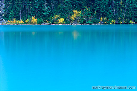 Fine art photograph of blue water, reflections, and fall colors