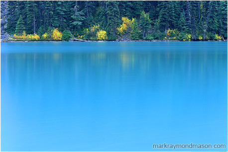 Fine art photograph of blue water, reflections, and fall colors