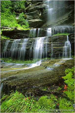 Fine art photograph of water flowing over mossy rock bluffs