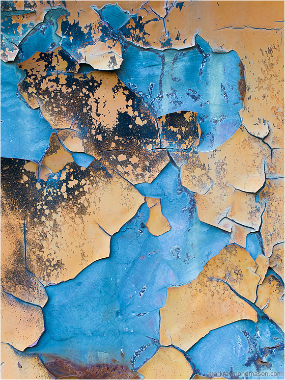 Cracking Sky, Pale Blue: Near Kamloops, BC, Canada (2013-07-06) - Abstract macro photograph showing large chunks of peeling orange paint falling away to reveal cool, blue-tinted metal beneath