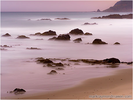Fine art landscape photograph of misty water around rocky islands in the last light of a coastal evening