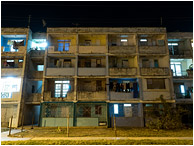 Apartment Block, Pale Lights: Santa Marta, Cuba (2017) - Fine art photograph showing lights in the windows of a very old and run-down apartment complex