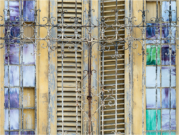 Glass, Slats, Bars: Regla, Cuba (2017-02-15) - Abstract photography showing small stained glass windows and wooden shutters behind ancient wrought-iron bars