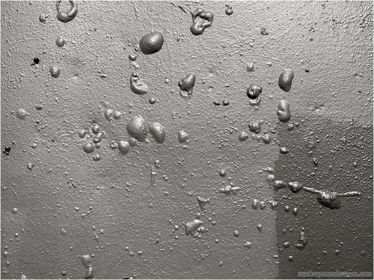 Concrete Wall, Blistered Paint: Vancouver, BC, Canada (2018-03-21) - Black and white abstract photograph showing a pattern of bubbles on a crudely painted concrete wall